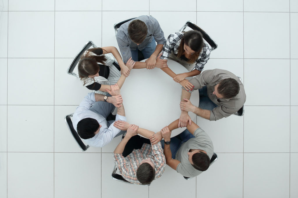 top view.The business team hold hands, forming a circle